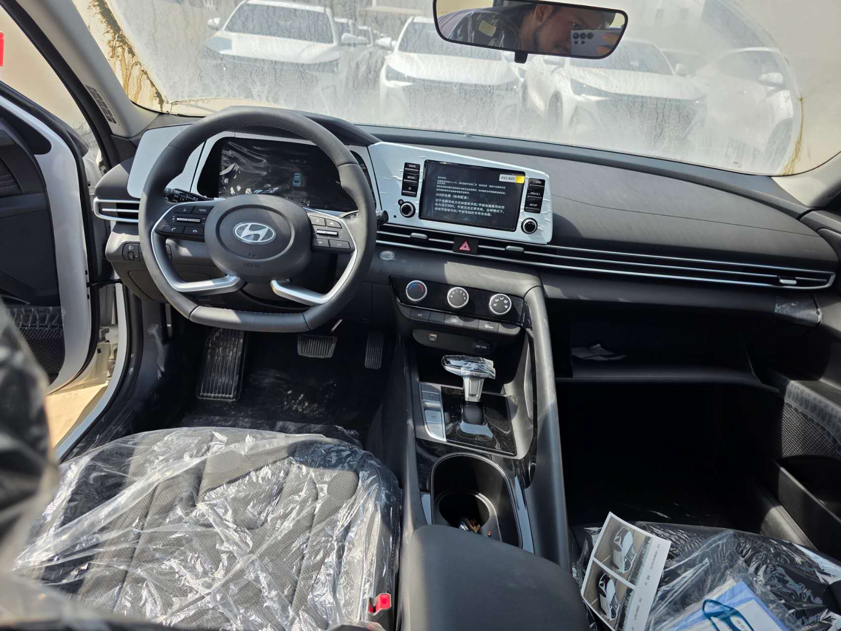 Hyundai Elantra front cabin showing the steering wheel, central display, climate controls and gear selector